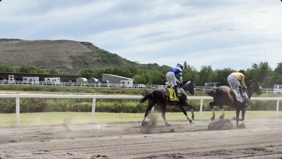 Two jockeys battle down the stretch at the Clinton E. Phipps Racetrack
