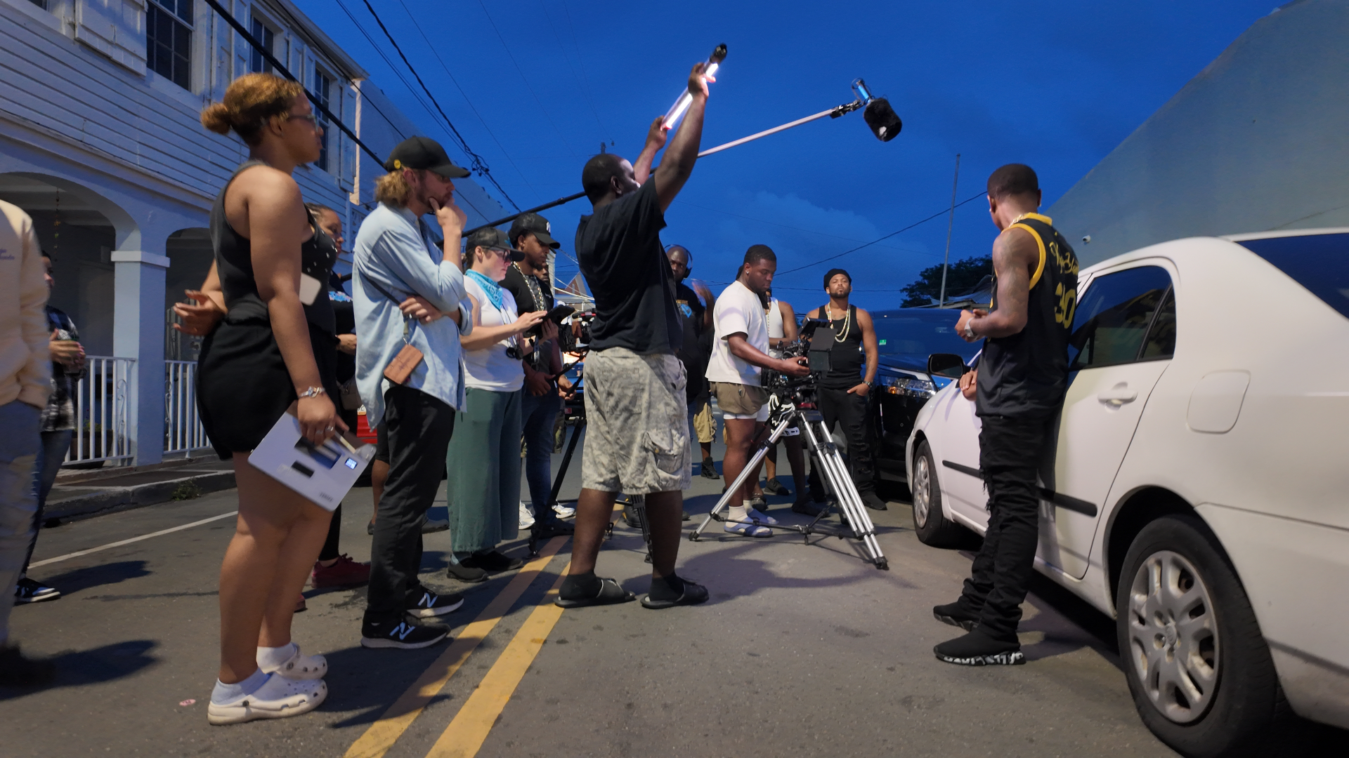 Night street shoot with talent, boom operator, and crew at blue hour