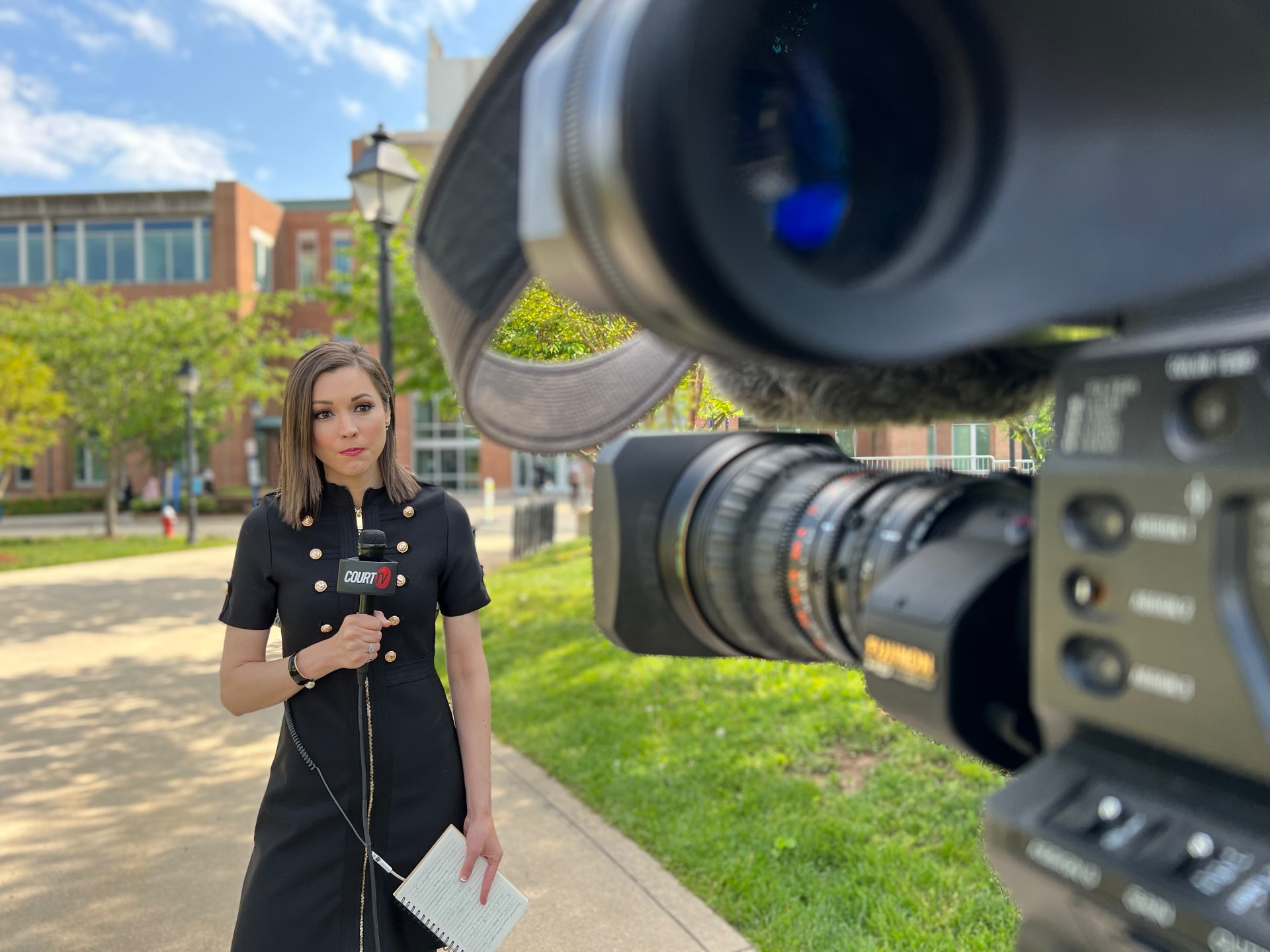 Court TV correspondent framed through a professional broadcast camera